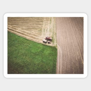 Aerial view of combine-harvester and tractor working in the field Sticker